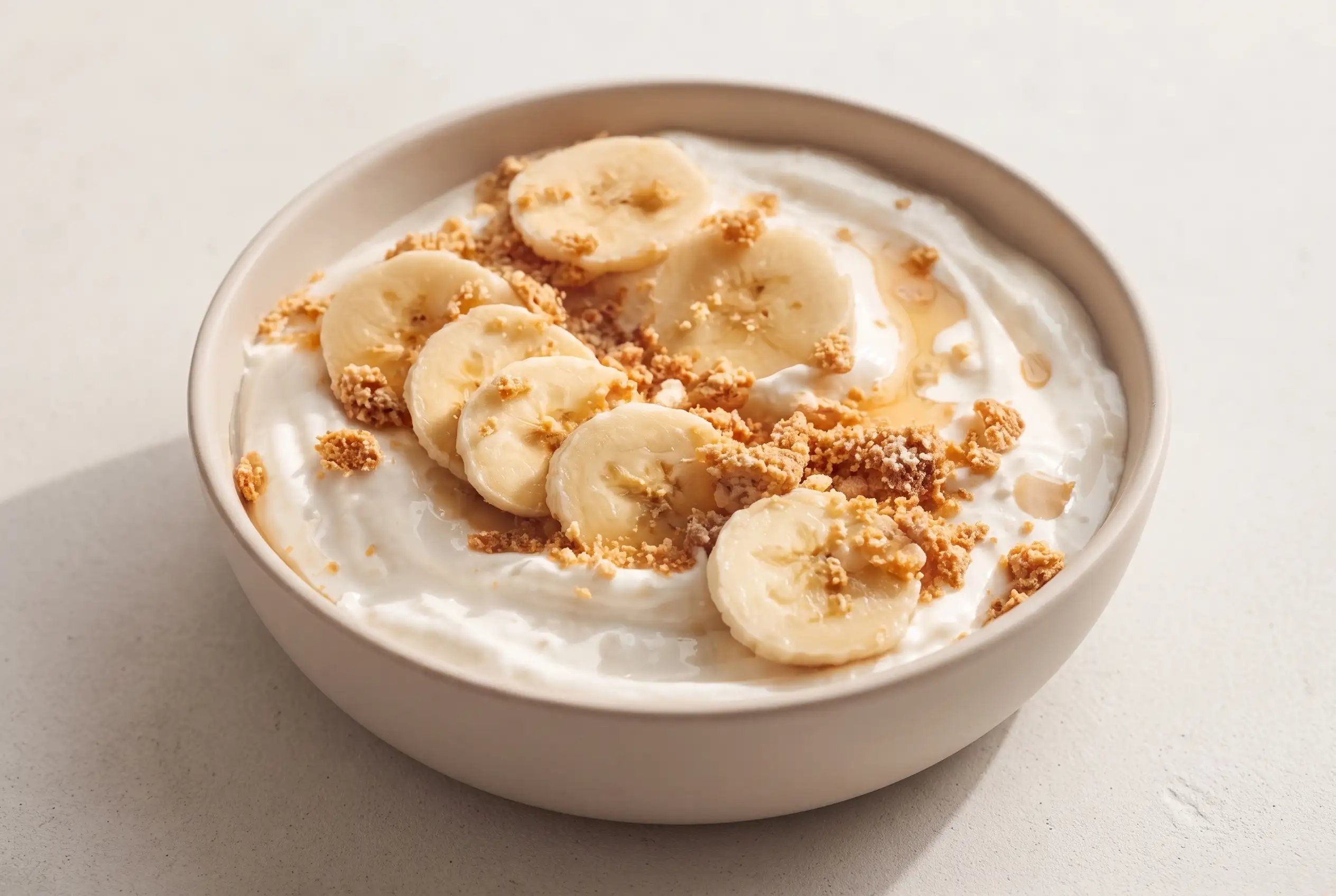 Banana pudding yogurt bowl with creamy yogurt, banana slices, and graham cracker topping