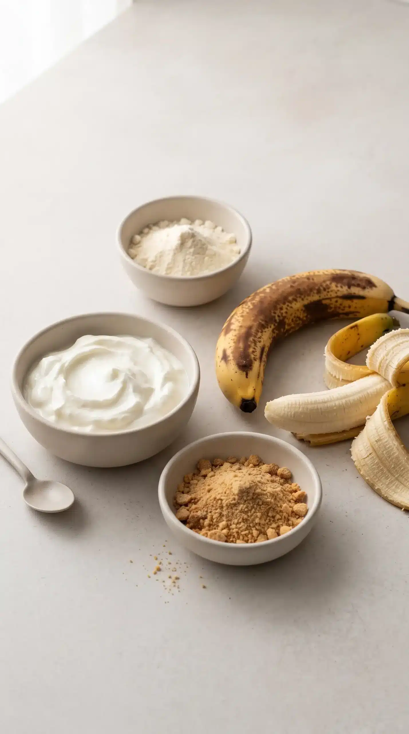 Greek yogurt, bananas, vanilla protein powder, and crushed graham crackers for a yogurt bowl