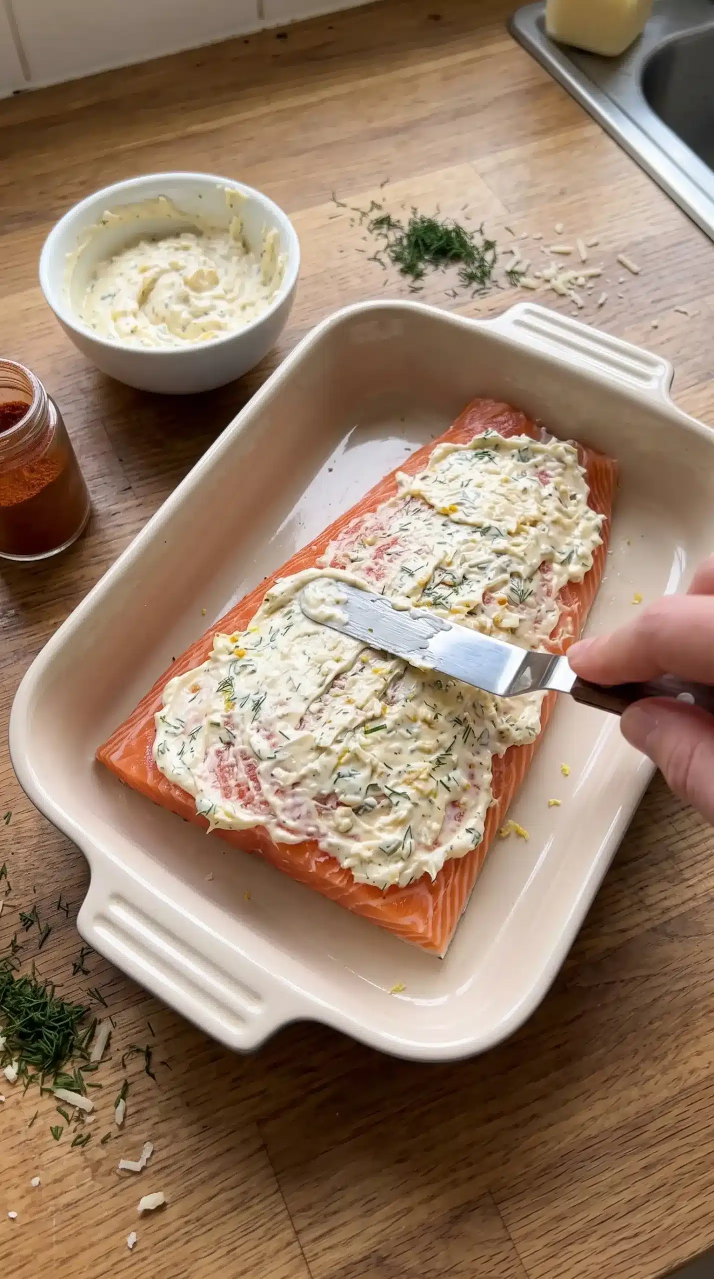Salmon fillet covered with creamy mayo Parmesan topping before baking