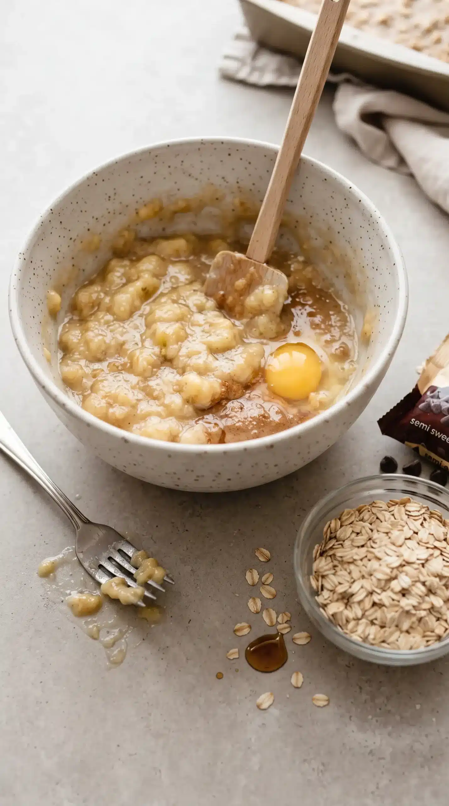 Mashed bananas and wet ingredients being mixed for banana oatmeal bars
