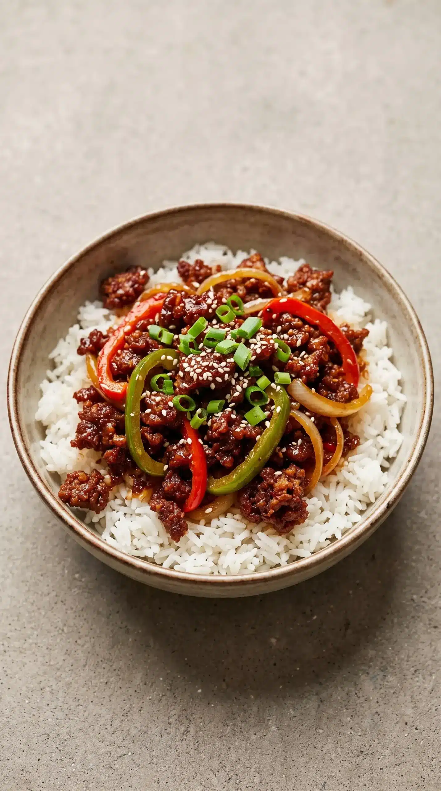 Finished crispy chilli beef rice with sticky sauce, vegetables, rice, and spring onion topping